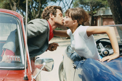 JEAN-PAUL BELMONDO ET ANNA KARINA SUR LE TOURNAGE DE PIERROT LE FOU MISE EN SCÈNE PAR JEAN-LUC GODARD, 1965 (©GEORGES PIERRE, COURTESY LA GALERIE DE L’INSTANT, PARIS)